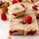 cut raspberry blondies drizzled with white chocolate.