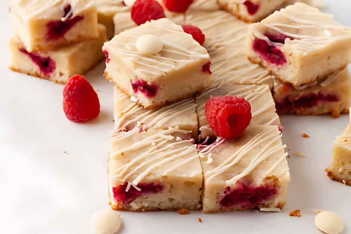 cut raspberry blondies drizzled with white chocolate.