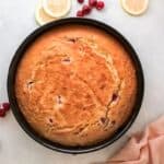 baked raspberry olive oil cake in a round cake pan.