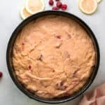 raspberry olive oil cake batter in a round baking pan.