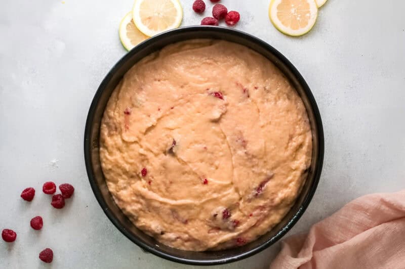 raspberry olive oil cake batter in a round baking pan.
