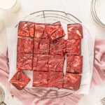 overhead view of cut red velvet cheesecake brownies on a wire rack.