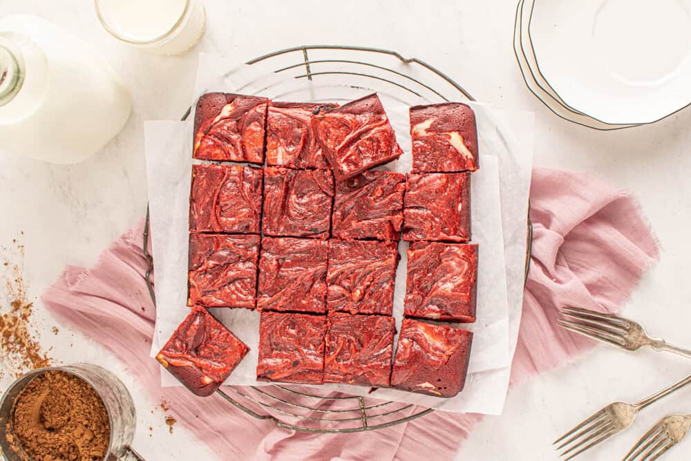 overhead view of cut red velvet cheesecake brownies on a wire rack.