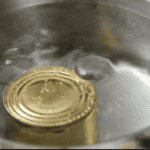 boiling a can of sweetened condensed milk in a large pot.