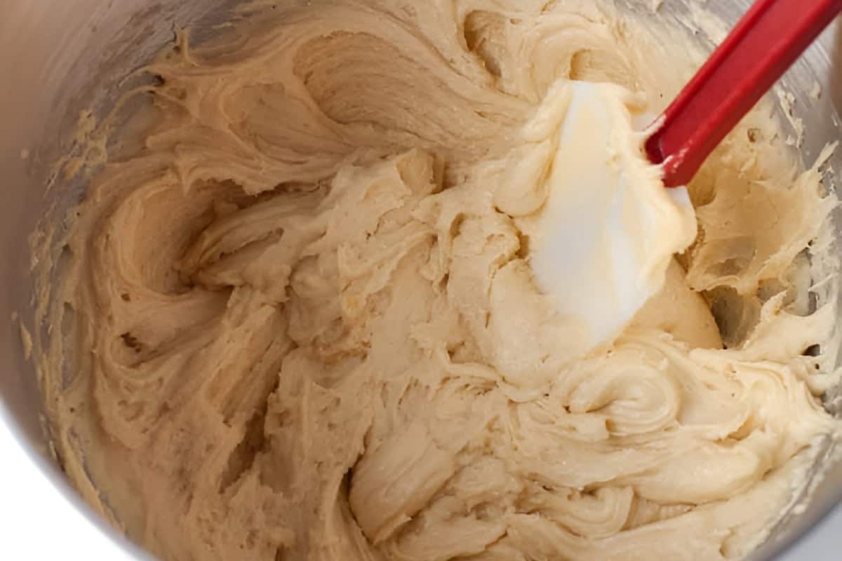 almond blondie dough in a stand mixer bowl with a rubber spatula.