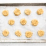 11 brown butter peanut butter cookie dough balls on a baking sheet.