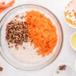 cake mix, shredded carrots, and chopped pecans in a glass bowl.