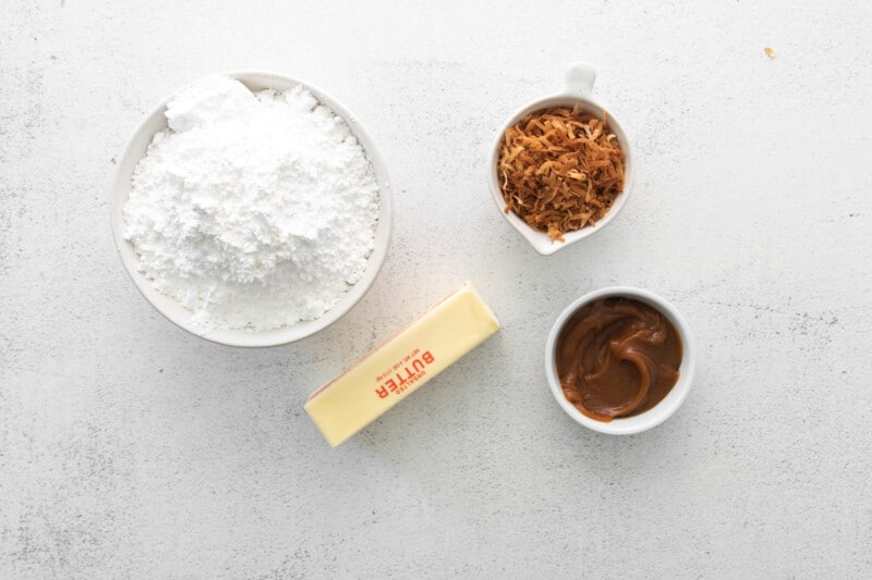 a bowl of flour, sugar, butter and cocoa powder on a white background.