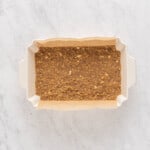 a white rectangular baking dish with brown dirt in it.