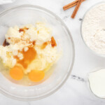 a bowl with eggs, flour, sugar and cinnamon.