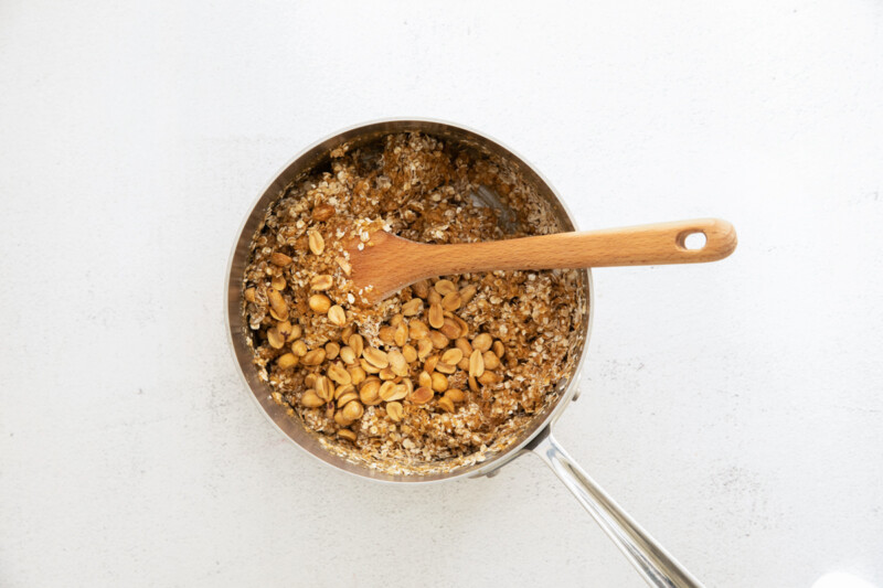 granola in a pan with a wooden spoon.