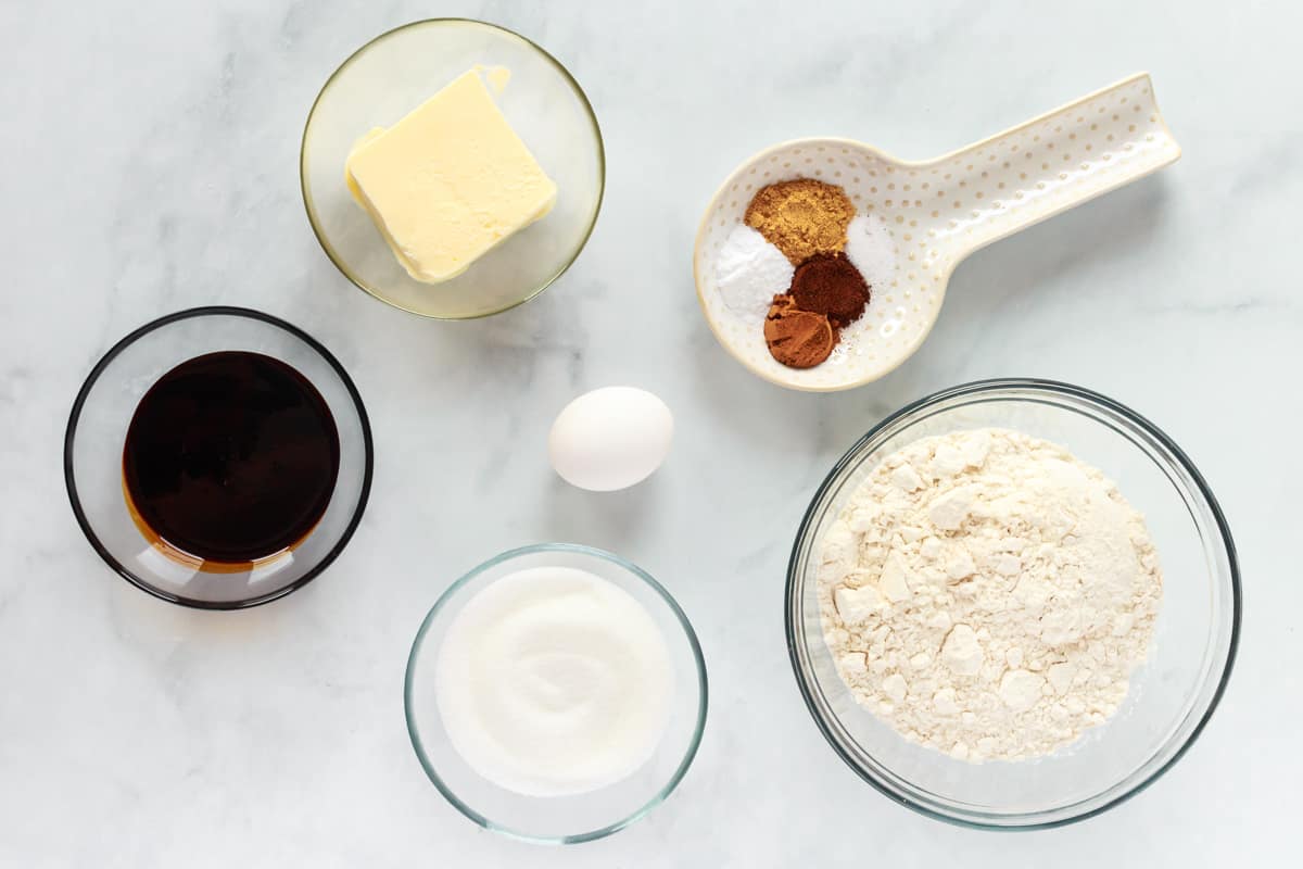 overhead view of ingredients for gingersnap cookies in individual bowls.