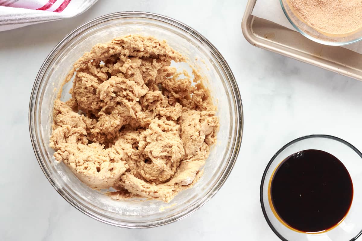 wet and dry ingredients for gingersnap cookies in a glass bowl.