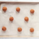 8 gingersnap cookie dough balls on a baking sheet.