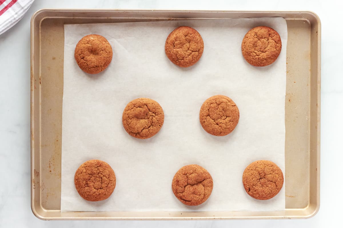 8 baked gingersnap cookies on a baking sheet.