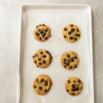 6 baked gluten free chocolate chip cookies on a baking sheet.