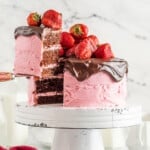a slice of chocolate cake with strawberries on a cake stand.