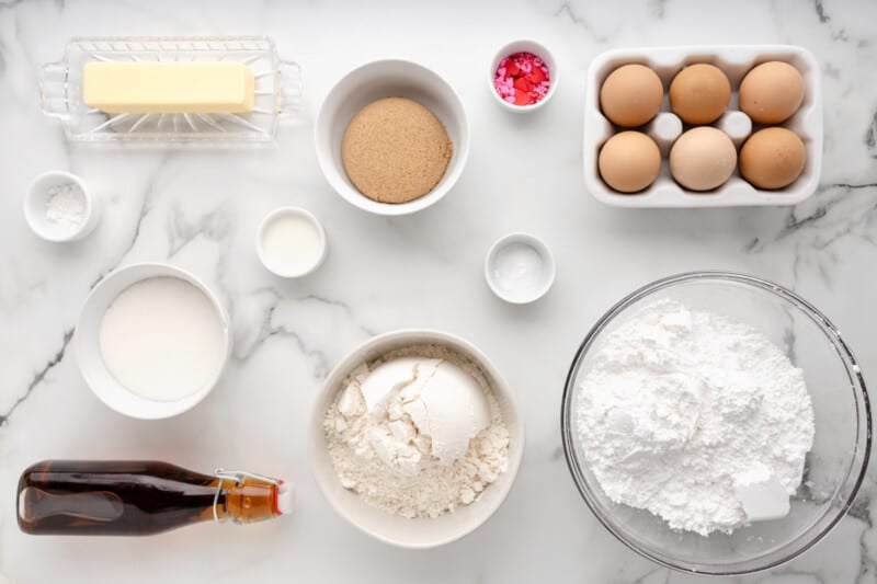 the ingredients for a cake are shown on a marble table.