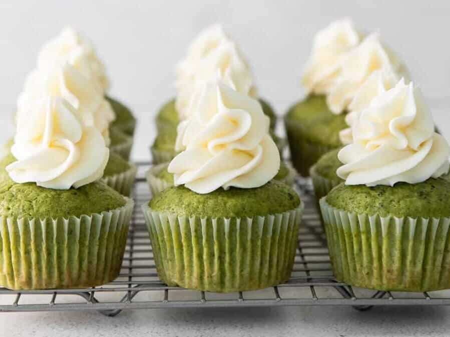 side view of 9 matcha cupcakes on a square wire rack.