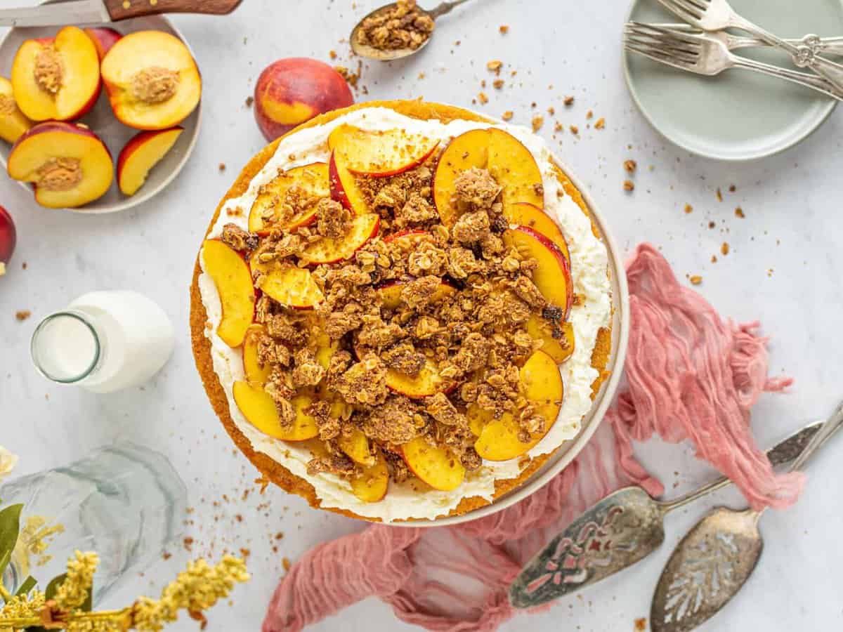overhead view of peach cobbler cake topped with cobbler crumbles and peach slices