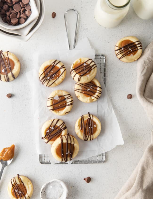 overhead view of 7 twix cookies on parchment paper on a small wire rack.