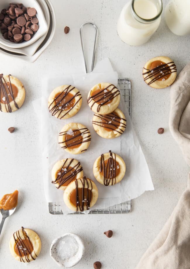 overhead view of 7 twix cookies on parchment paper on a small wire rack.