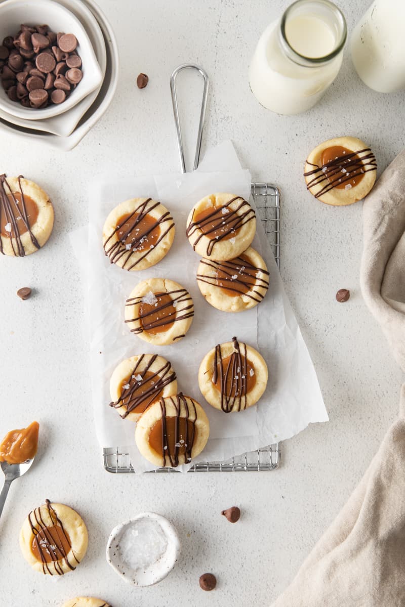 overhead view of 7 twix cookies on parchment paper on a small wire rack.