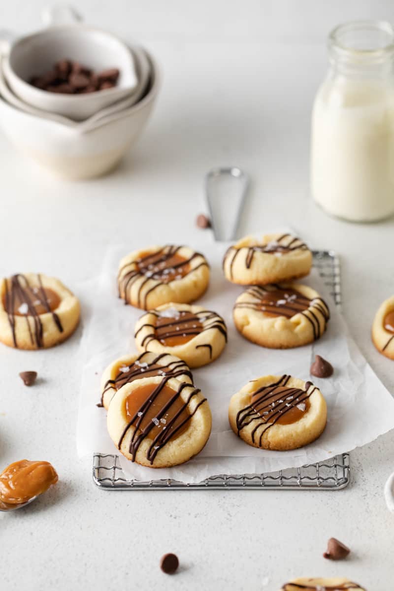 close-up three-quarters view of 7 twix cookies on parchment on a small wire rack.