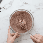 dry chocolate cake mix ingredients in a glass bowl with a whisk.