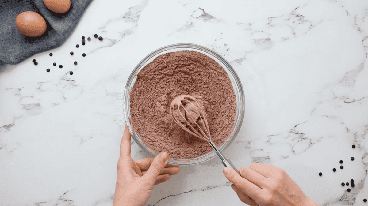 dry chocolate cake mix ingredients in a glass bowl with a whisk.