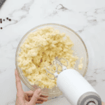 creaming butter and sugar in a glass bowl with a hand mixer.