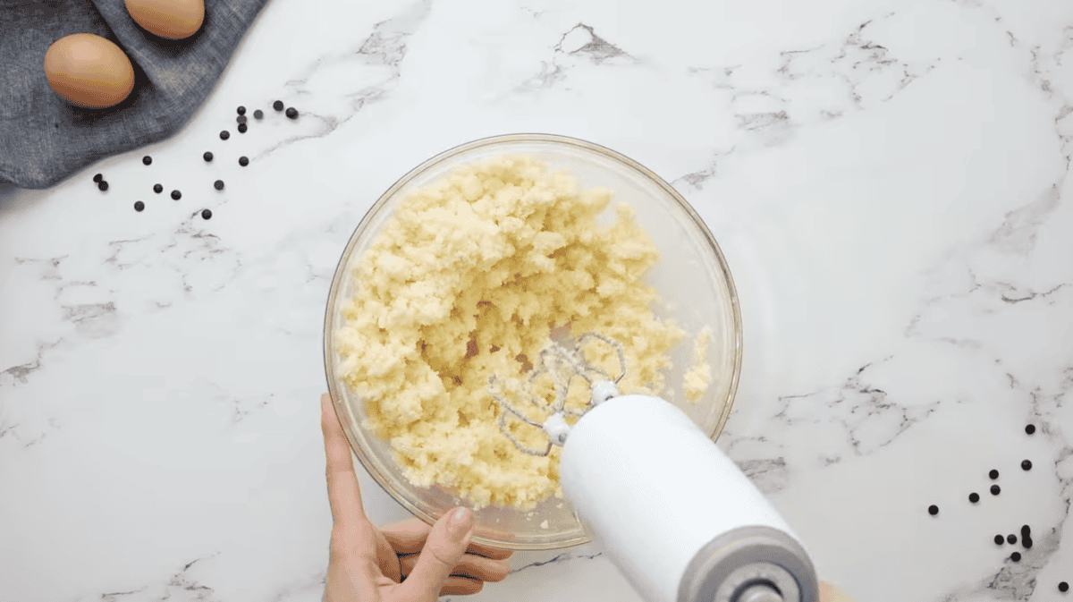 creaming butter and sugar in a glass bowl with a hand mixer.