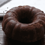 baked chocolate pound cake on a cooling rack set in a baking sheet.