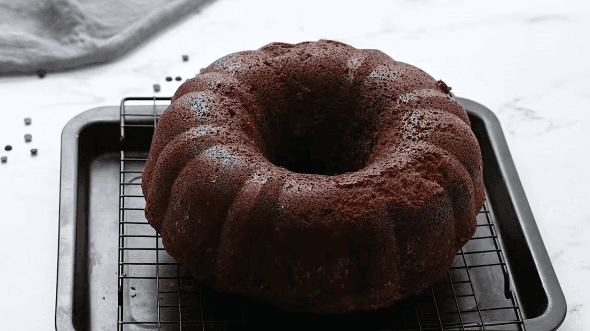 baked chocolate pound cake on a cooling rack set in a baking sheet.