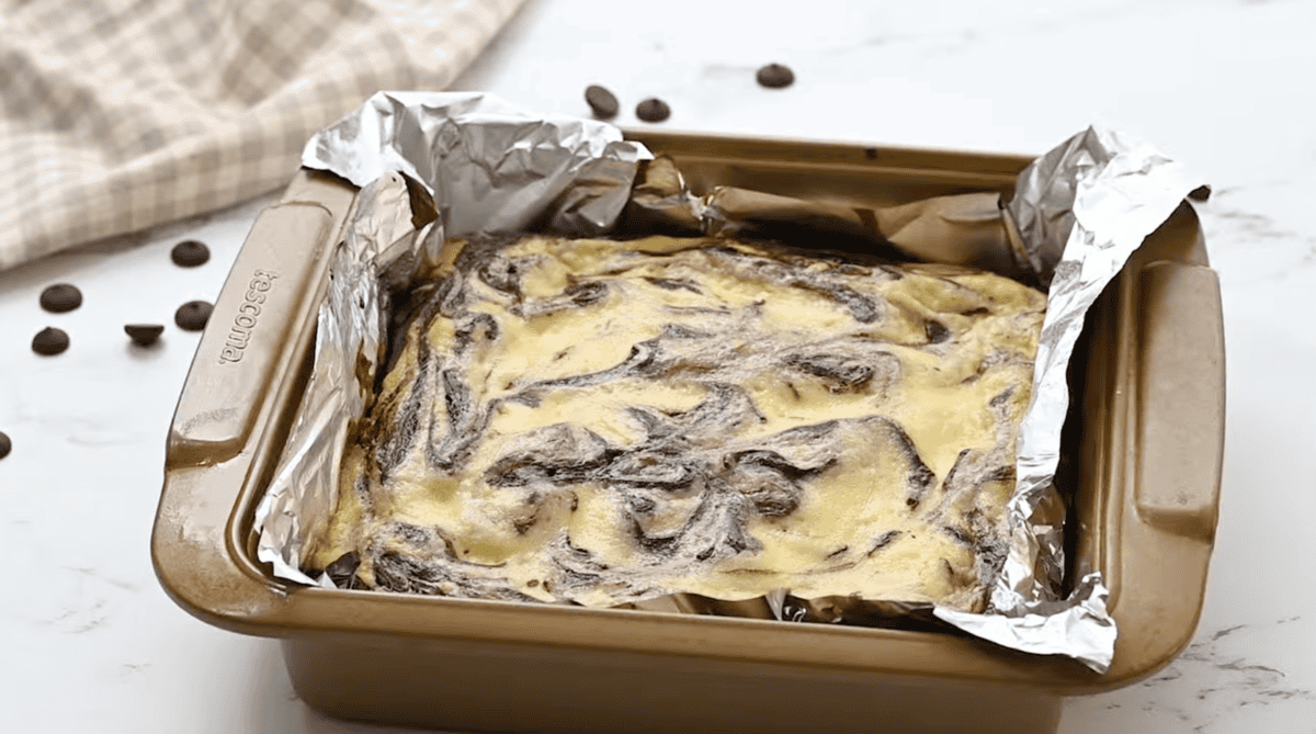 baked cream cheese brownies in a foil lined baking pan.