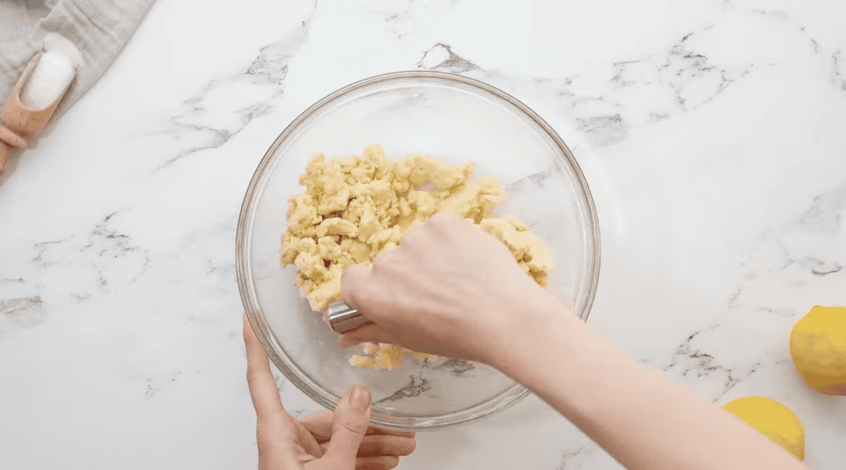 cutting butter into dough with a pastry cutter.