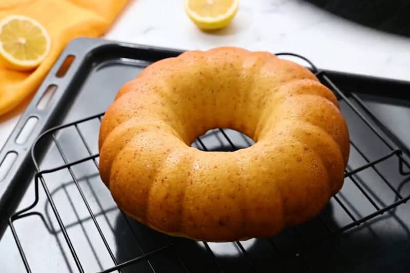freshly baked lemon buttermilk bundt cake on a wire cooling rack.