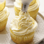 frosting lemon cupcakes with lemon frosting.