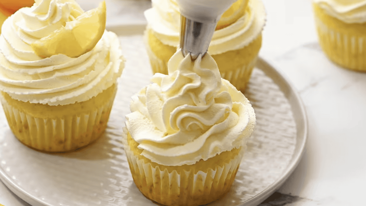 frosting lemon cupcakes with lemon frosting.