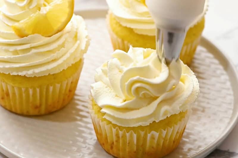 frosting lemon cupcakes with lemon whipped cream frosting.