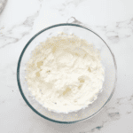 beaten cream cheese in a glass bowl.