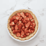 halved strawberries in a baked pie crust.