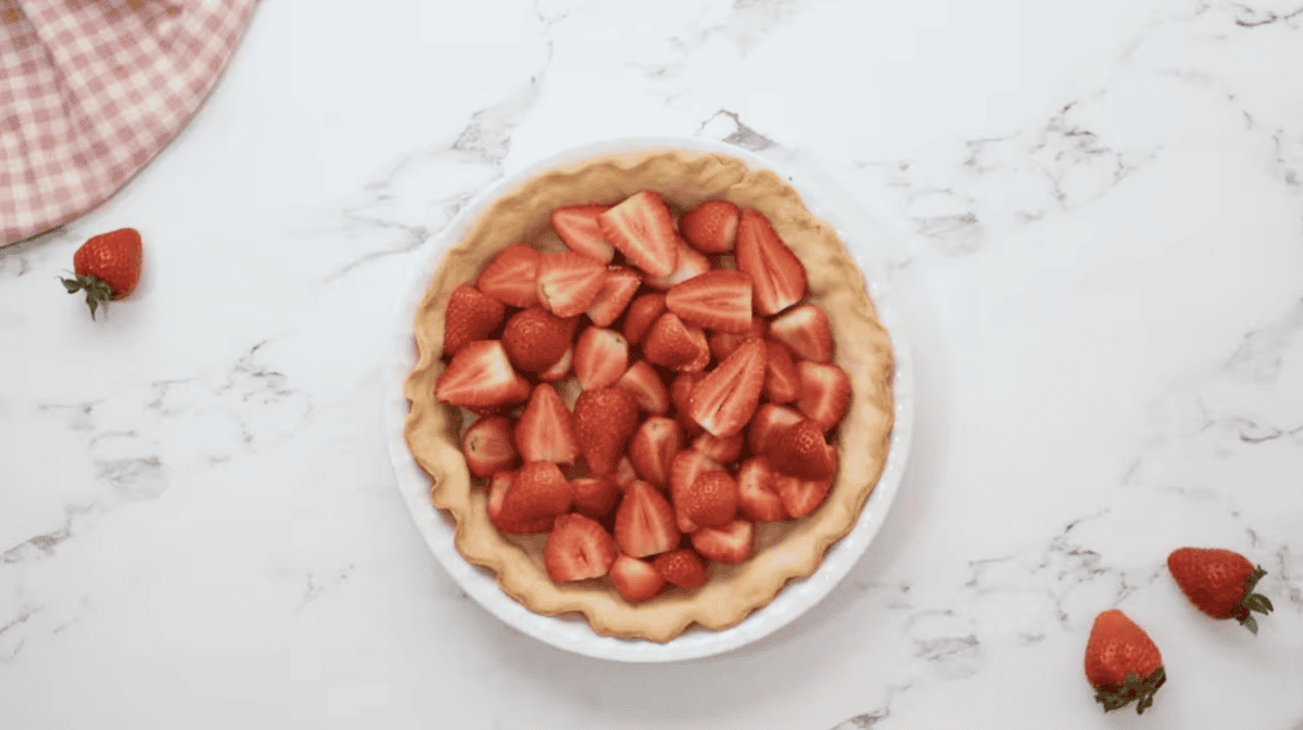 halved strawberries in a baked pie crust.