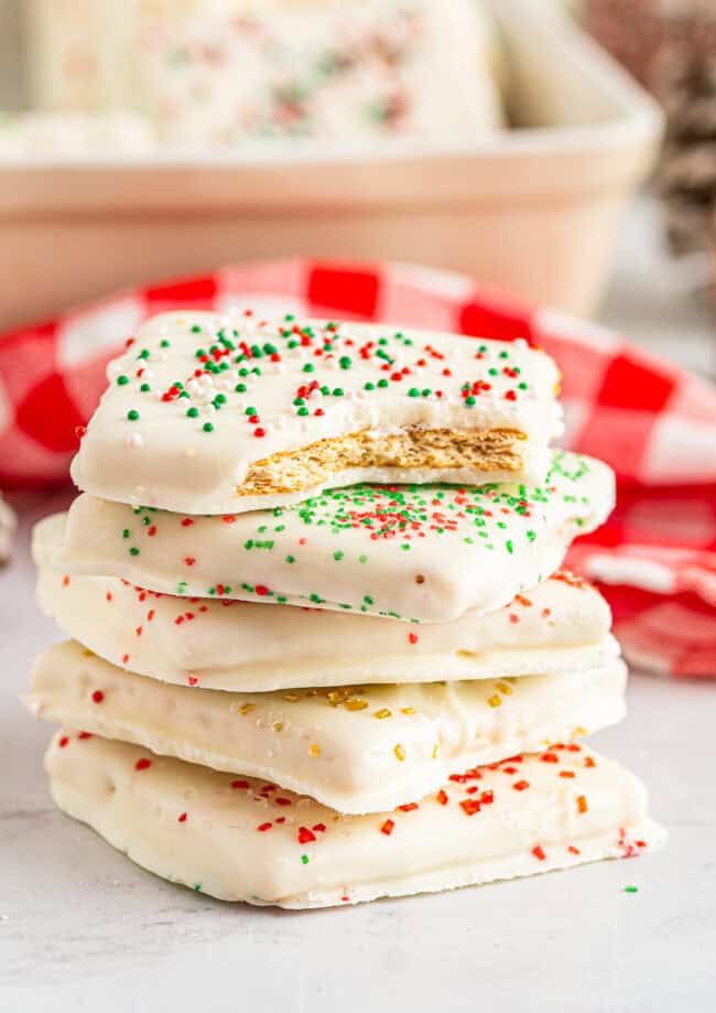 a bitten white chocolate graham cracker on a stack of 4 crackers.