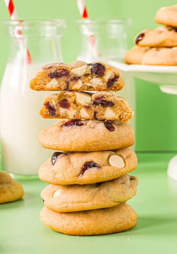 a halved white chocolate cranberry cookie on top of a stack of cookies.