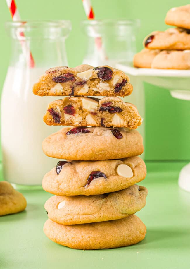 a halved white chocolate cranberry cookie on top of a stack of cookies.