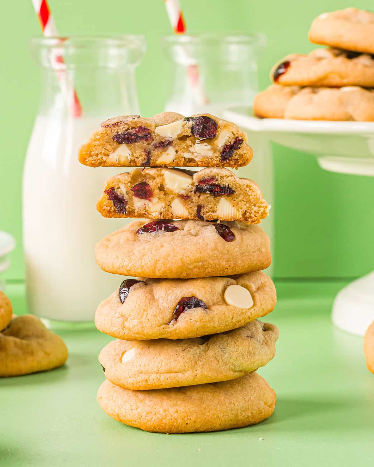 a halved white chocolate cranberry cookie on top of a stack of cookies.