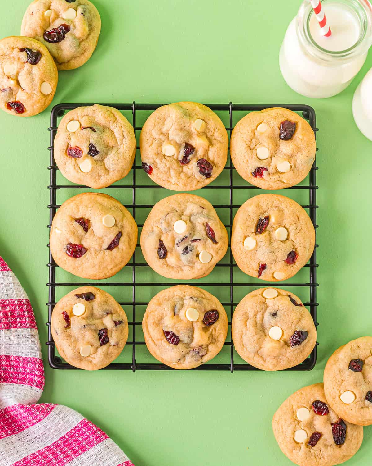 overhead view of 9 white chocolate cranberry cookies on a wire rack.