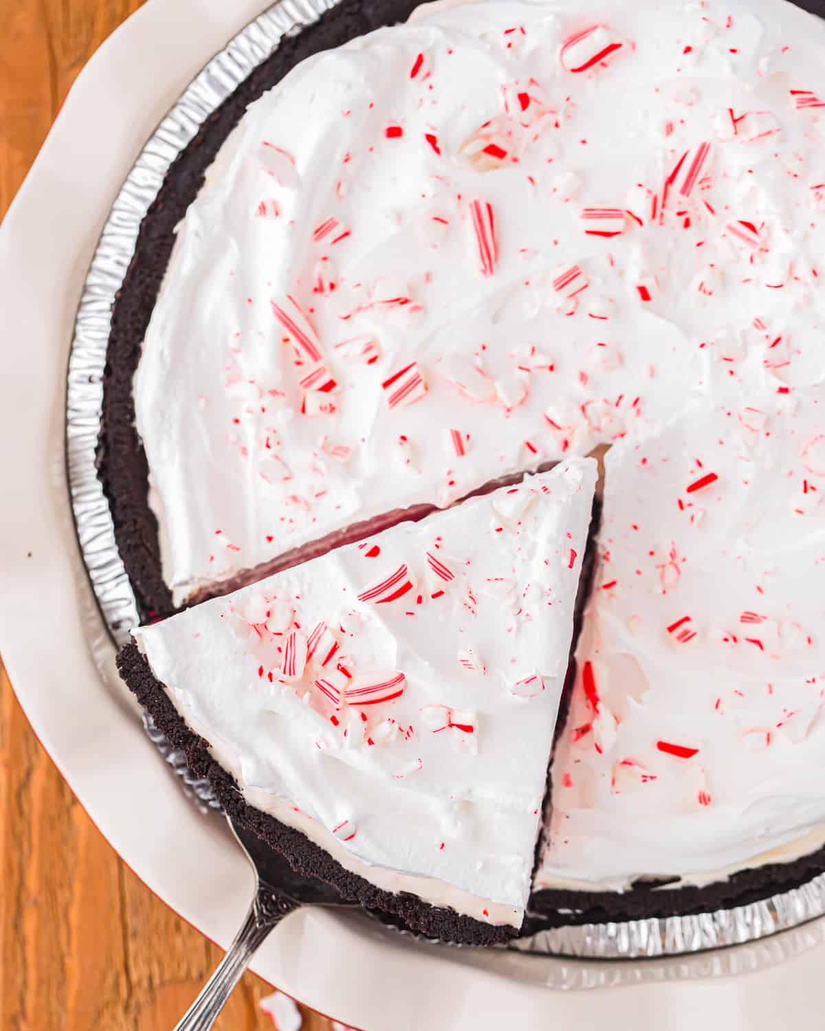 overhead view of a cake server removing a slice of peppermint pie.