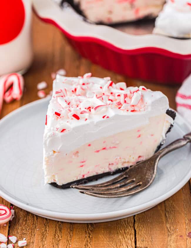 a slice of peppermint pie on a white plate with a fork.